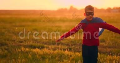 穿着超级英雄服装和面具的男孩在日落时跑过田野，梦想着幻想